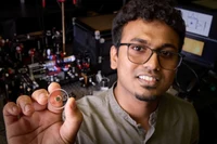 Kirankumar Karkihalli Umesh mit dem Herzstück des Experiments, einem mit Polymerstrukturen bedruckten Resonatorspiegel.