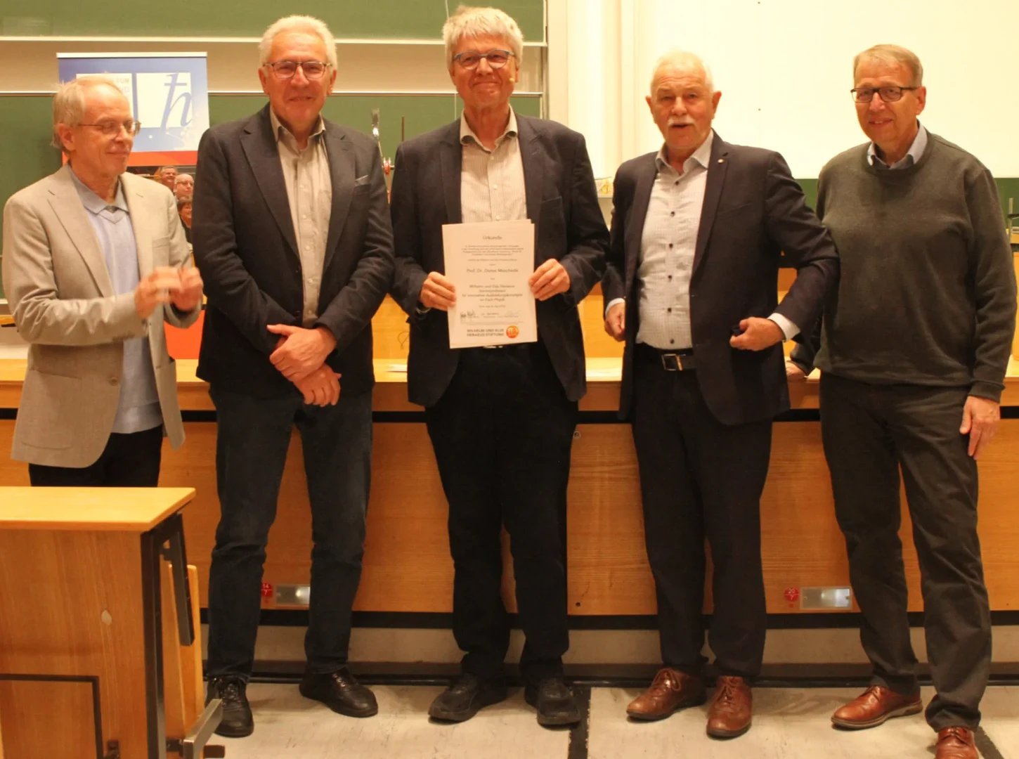 Verleihung der Urkunde: (von links) - Prof. Johann Kroha (Organisator des Physikalischen Kolloquiums), Dekan Prof. Walter Witke, Prof. Dieter Meschede, Prof. Jürgen Mlynek (Vorstandsvorsitzender der Wilhelm und Else Heraeus-Stiftung) und Prof. Klaus Sandmann (Prorektor für Studium, Lehre und Hochschulentwicklung).