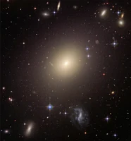 The huge elliptical galaxy ESO 325-G004 - shone 10,000 times brighter when it formed than it does today. These types of galaxies briefly lit up the entire universe – and contributed to the background radiation we can measure today.