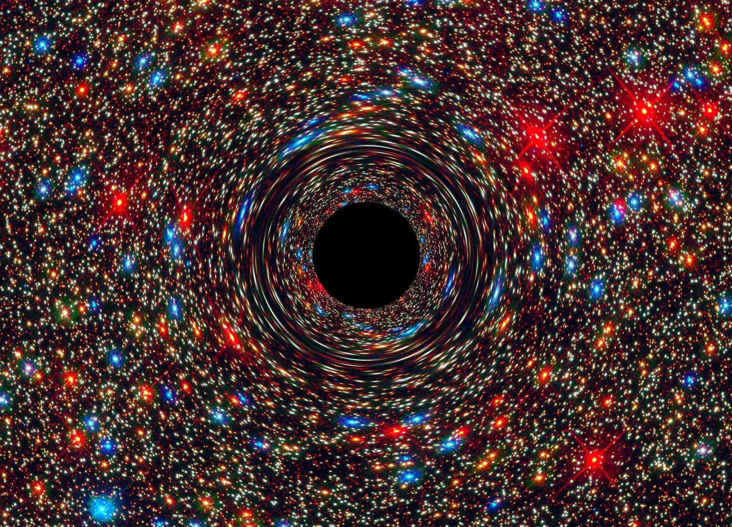 This computer-simulated image shows a supermassive black hole at the core of a galaxy: - The black region in the center represents the black hole’s event horizon, where no light can escape the massive object’s gravitational grip. The black hole’s powerful gravity distorts space around it like a funhouse mirror. Light from background stars is stretched and smeared as the stars skim by the black hole. Apart from its smaller radius, a medium-sized black hole looks similar.